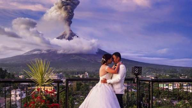 Pasangan pengantin dengan latar belakang erupsi gunung Mayon