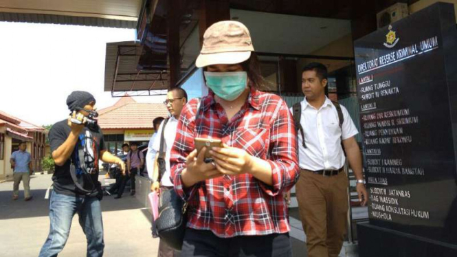 OPA (bermasker), perawat korban pelecehan seksual di National Hospital, setelah menjalani pemeriksaan di Markas Kepolisian Daerah Jawa Timur di Surabaya pada Selasa, 30 Januari 2018.