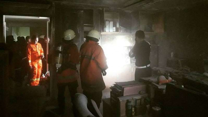 Petugas memeriksa kondisi ruangan yang terbakar di Gedung DPR