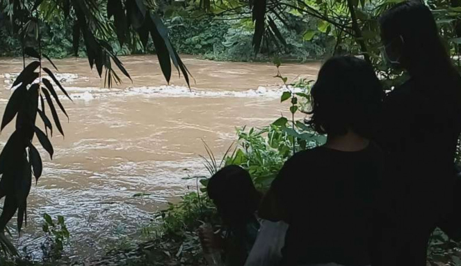 Warga depok saksikan kenaikan debit air sungai Ciliwung.