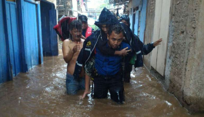 Petugas mengevakuasi korban banjir di Pasar Minggu, Jakarta Selatan.