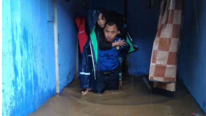 Petugas mengevakuasi korban banjir di Pasar Minggu, Jakarta Selatan.