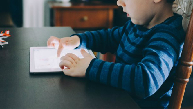 Anak mengakses internet di tablet.
