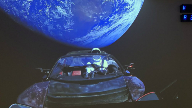 Selfie Starmen di belakang mobil listrik dengan latar belakang bumi