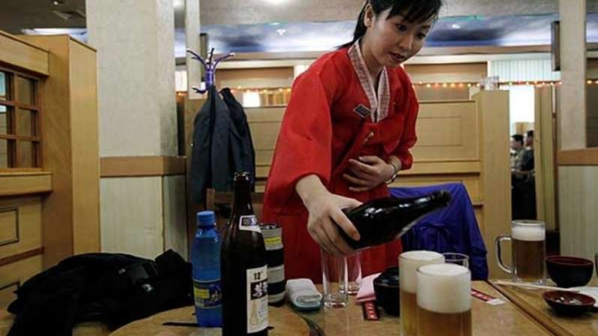 Seorang pelayan menuangkan bir yang dijual di Kota Pyongyang Korea Utara