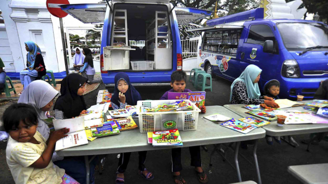 Sejumlah anak bersama ibu mereka membaca buku di stand Mobil Buku Keliling (ilustrasi)