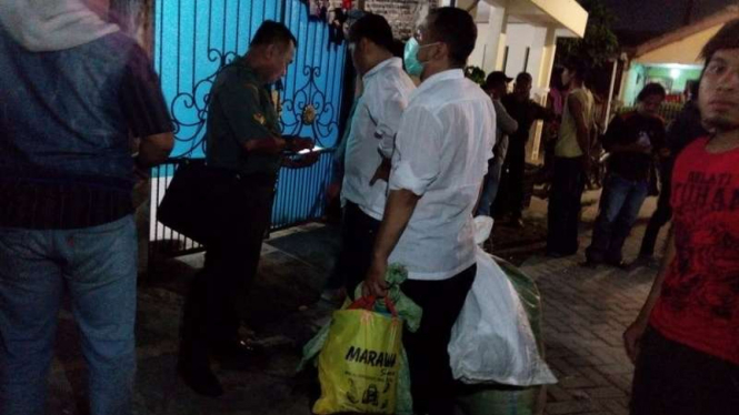 Petugas membawa barang bukti yang ditemukan di lokasi pembunuh ibu dan anak.