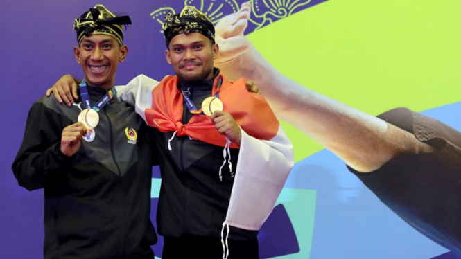 Atlet pencak silat Indonesia, Hendy (kanan) dan Yolla Primadona Jampil (kiri)