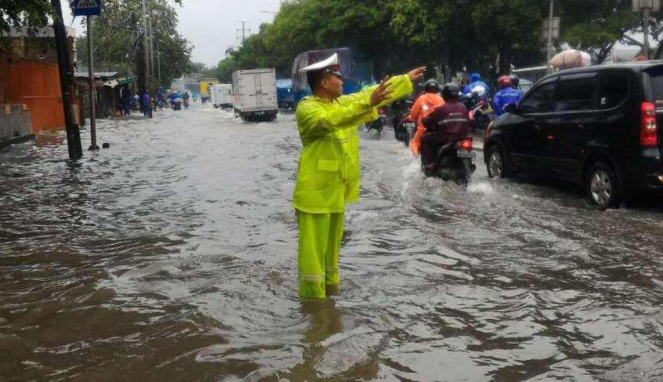 Petugas mengatur lalu lintas imbas banjir depan Samsat Jakarta Barat.