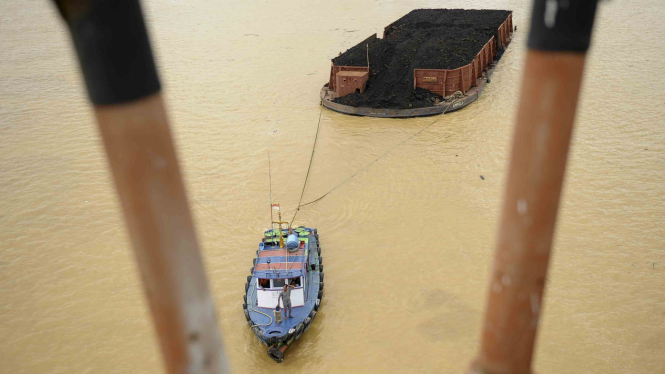 Kapal Tongkang membawa batu bara melintasi Sungai Batanghari