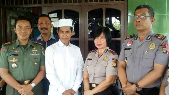 Abu Bakar Madris (berbaju putih), seorang dari belasan kiai yang diancam dibunuh, bersama aparat TNI dan Polri yang berkunjung ke rumahnya di Depok, Jawa Barat, pada Senin, 5 Maret 2018.