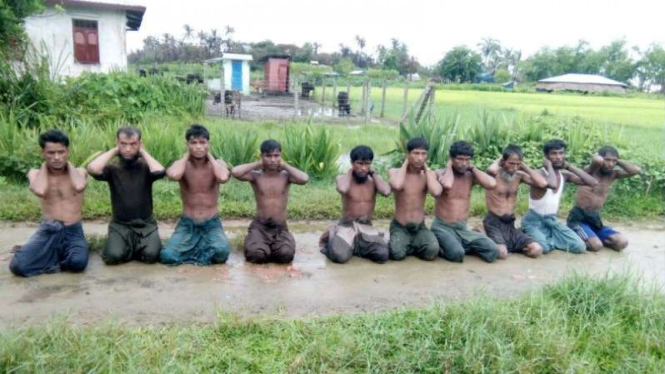 Para pria muslim Rohingya berlutut menyerah di kampung  Inn Din, Myanmar.