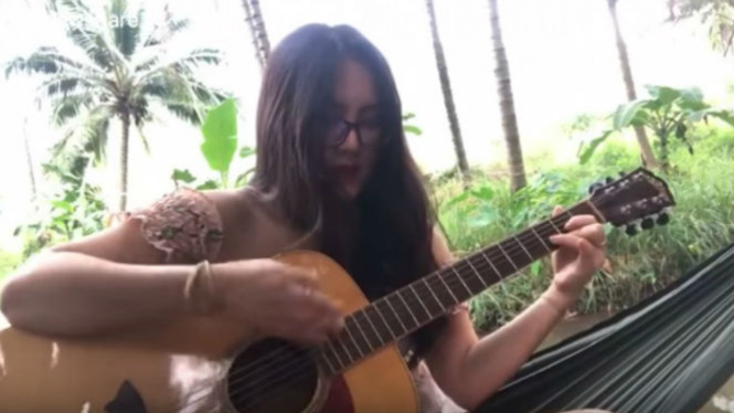 Wanita bermain gitar.