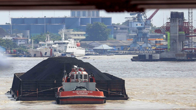 Barcaza de carbón que transporta al cruzar el río Musi, Palembang