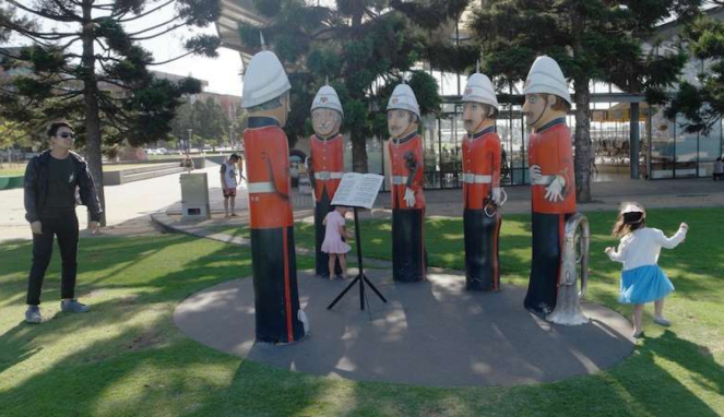 Anak-anak bermain di antara patung-patung kayu di Kota Geelong