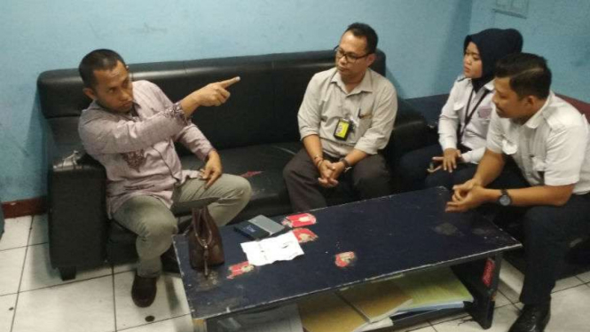 Asisten Pidana Khusus Kejaksaan Tinggi Sulawesi Utara, M Rawi (kiri), berang di Bandara Internasional Juanda Surabaya, Jawa Timur, pada Minggu, 11 Maret 2018.