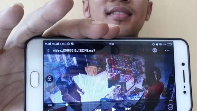 Foto rekaman video CCTV yang memperlihatkan seorang warga Iran mencuri uang di kasir sebuah minimarket di Depok, Jawa Barat, pada Minggu, 18 Maret 2018.