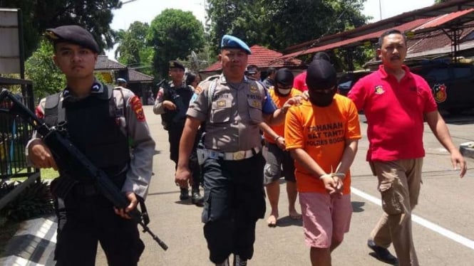 Polisi memperlihatkan dua tersangka pembunuhan sadis seorang wanita di Bogor, Jawa Barat, pada Rabu, 21 Maret 2018.