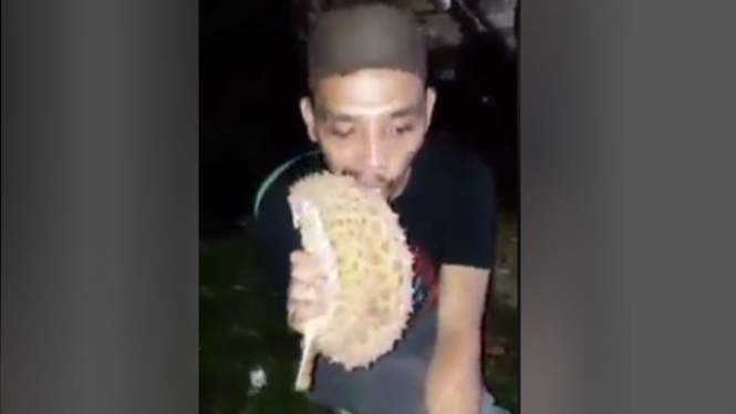 Aksi pria memakan kulit durian.