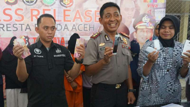 Polisi menunjukkan barang bukti berupa uang Rp4 juta dari germo PSK online yang ditangkap di Aceh Besar, Aceh, pada Jumat, 23 Maret 2018.