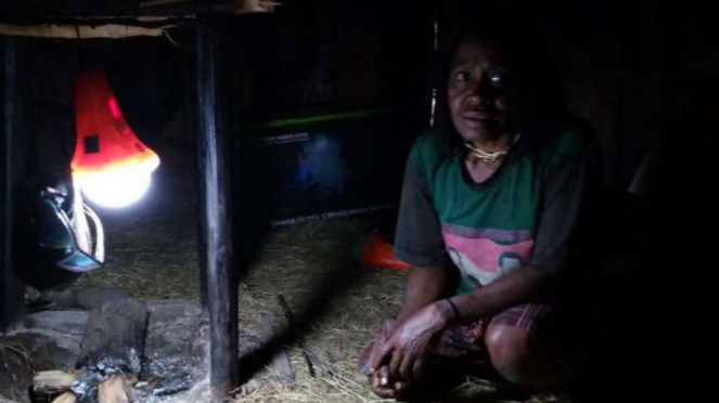 seorang warga pedalaman Papua menikmati listrik.