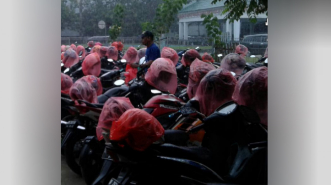 Juru parkir membungkusi helm.