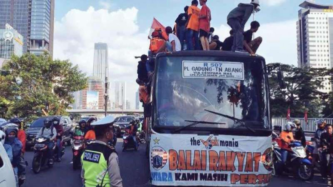 Jakmania di atap Bus Mayasari Bakti.