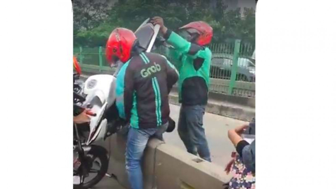 Ojek online gotong motor keluar dari jalur Busway