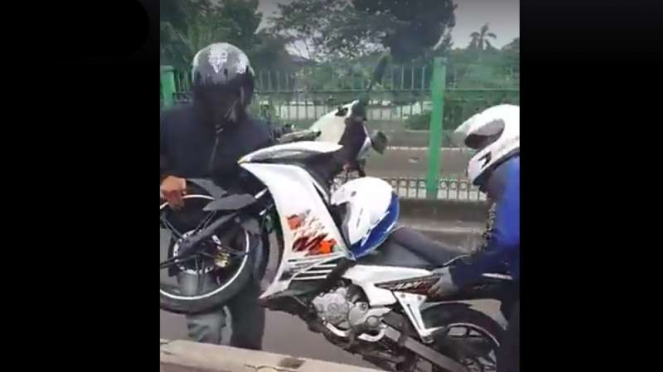 Aksi gotong motor melewati jalur Transajakarta