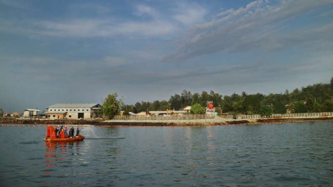 Petugas membersihkan tumpahan minyak di pantai Balikpapan