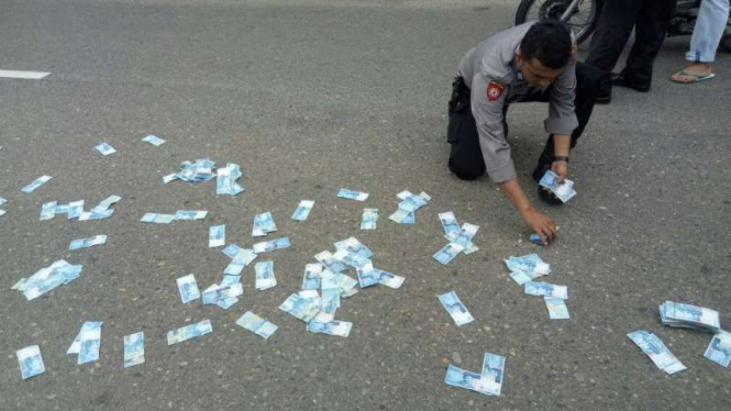 Uang hasil rampokan yang disebar pelaku di Kota Sawahlunto, Sumatera Barat.