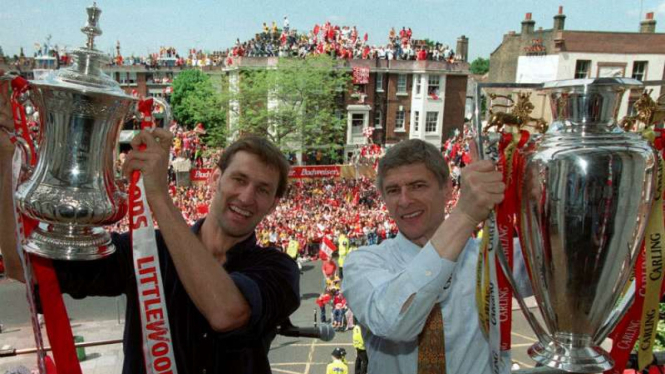Manajer Arsenal, Arsene Wenger, dengan trofi Premier League dan Piala FA.