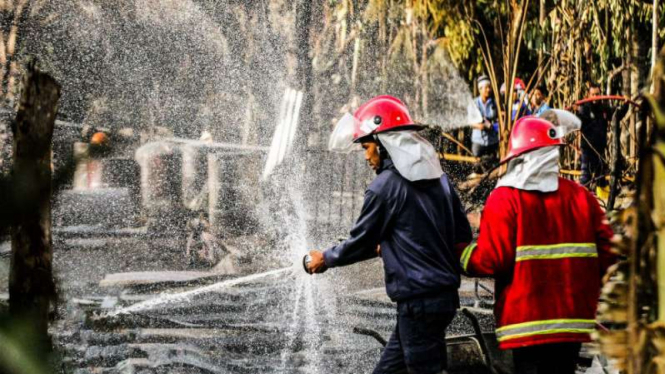Petugas pemadam kebakaran melakukan pendinginan area ledakan sumur minyak ilegal