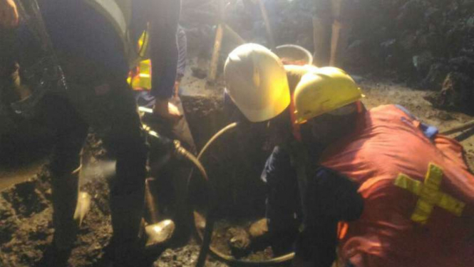 Tim penyelamat mengevakuasi seorang pekerja galian yang tewas setelah tertimbun tanah longsor dari saluran air minum, di Jakarta Utara, Selasa malam, 1 Mei 2018. 