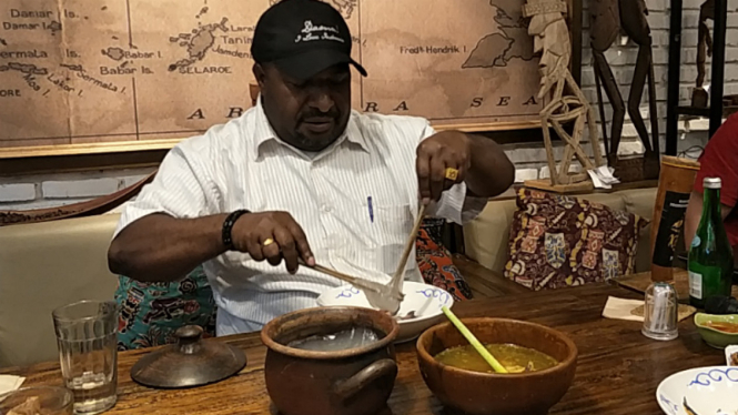 Bupati Oksibil, Costan Oktemka, memeragakan cara makan papeda
