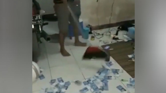 Pria menyapu uang pecahan Rp50 ribuan.