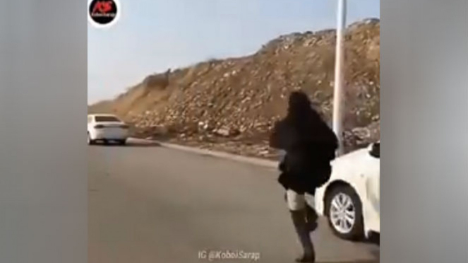 Wanita mengejar mobil.