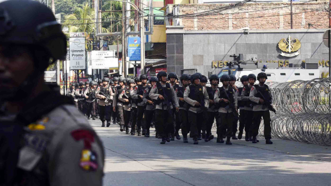 Petugas Brimob melintas di depan Mako Brimob Kelapa Dua, Depok, Jawa Barat
