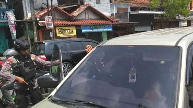 Petugas melakukan razia di depan Asrama Brimob, Kelapa Dua, Depok.