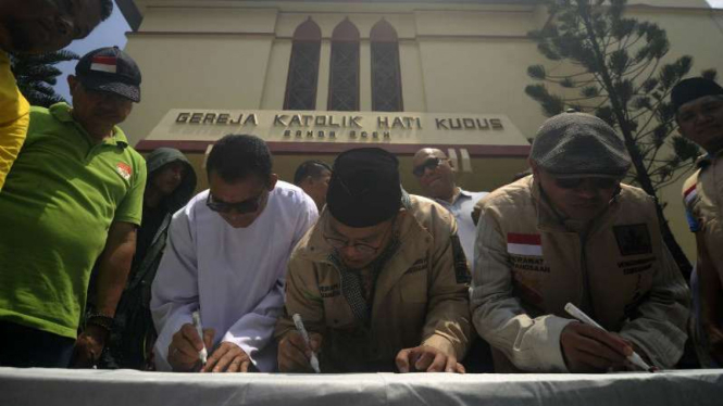 Ketua Pusat Pemuda Muhammadiyah dan Pastur Gereja menandatangani petisi untuk kebersamaan dalam keberagaman antarummat di Gereja Katolik Hati Kudus, Banda Aceh, Minggu, 13 Mei 2018.