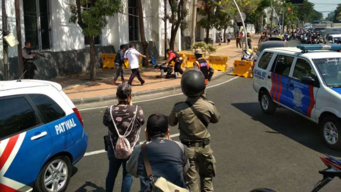 Seorang pria (berjongkok-bertopi hitam) ditangkap polisi di Jembatan Merah, Surabaya, pada Senin, 14 Mei 2018.