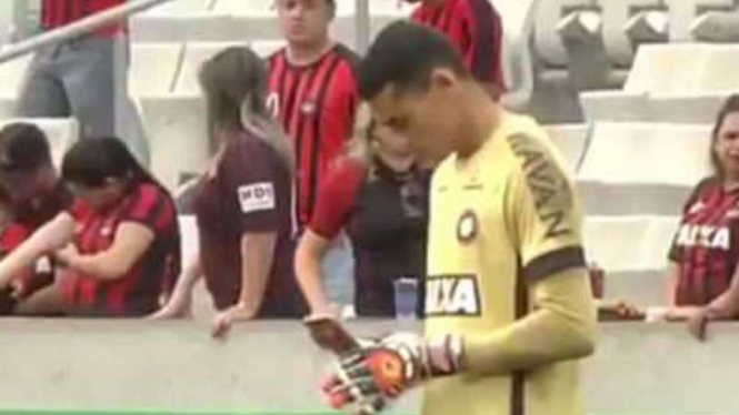 Kiper Atletico Paranaense, Santos, bermain handphone saat pertandingan.