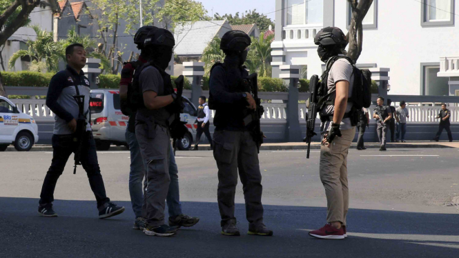 Polisi berjaga-jaga dekat lokasi ledakan bom di Mapolrestabes Surabaya, 14 Mei 2018.