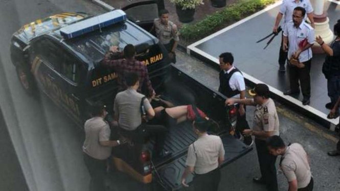 Polisi mengevakuasi salah satu korban luka di Polda Riau.