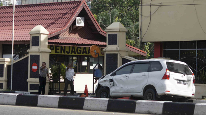 Mobil minibus yang digunakan pelaku teror dalam kondisi rusak di depan pintu masuk Polda Riau