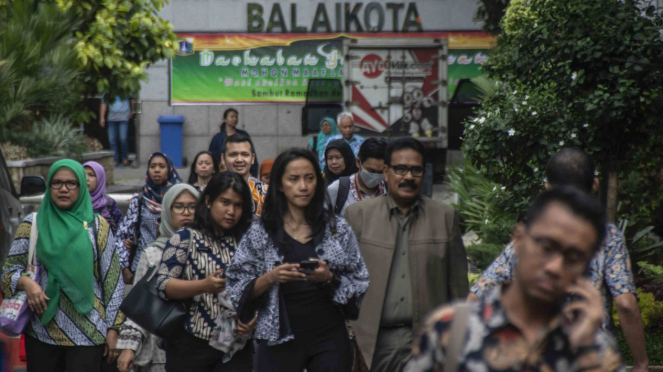 Sejumlah Pegawai Negeri Sipil (PNS) bergegas meninggalkan kompleks Balaikota di Jakarta.