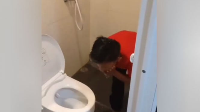 Bocah cuci muka di pancuran toilet.