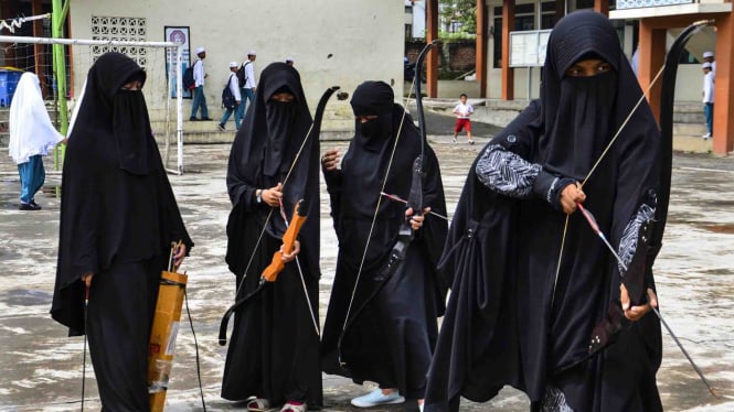 Santriwati bercadar bersiap membidik target busur panah saat mengikuti latihan olahraga Ekstrakurikuler Panahan di Pondok Pesantren Al-Idrisiyyah, Kampung Pagendingan, Kabupaten Tasikmalaya