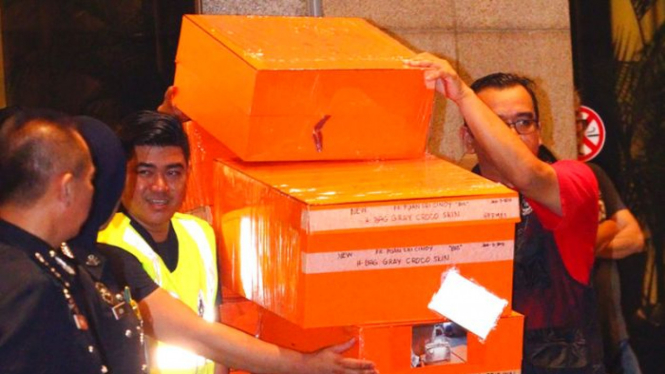 Polisi bersiap memuat barang-barang sitaan ke dalam truk di Kuala Lumpur, 18 Mei 2018. Polisi Malaysia menyita 284 kotak tas desainer dan lusinan tas berisi uang dan perhiasan dalam penggeledahan di sejumlah properti terkait Najib Razak.