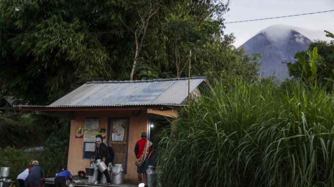 Warga beraktivitas di Dusun Kalitengah Lor, Glagaharjo dengan latar belakang Gunung Merapi